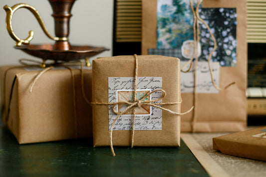 Gifts wrapped in plain brown kraft paper and tied with natural twine, with handwritten paper labels.