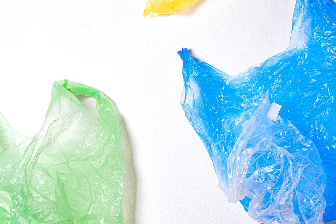 Colourful scrunched soft plastic shopping bags laid out on a white background