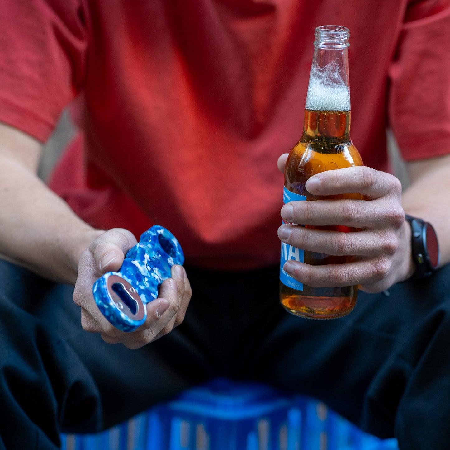 Deep Blue recycled bottle opener held next to an open beer