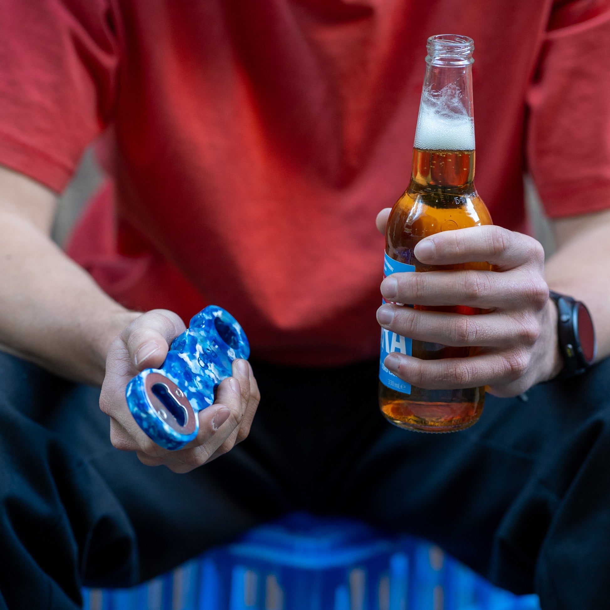 Deep Blue recycled bottle opener held next to an open beer