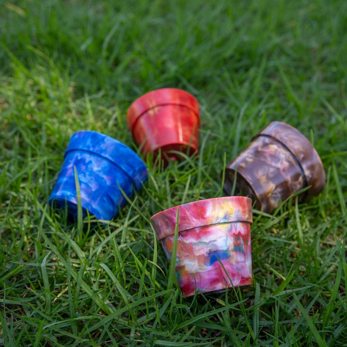 Four BRAD recycled plastic pot plants in all colours - Blueberry, Strawberry, Chocolate and Fruit Salad - on grass, complete 4-pack collection of sustainable Australian planters from recycled plastic