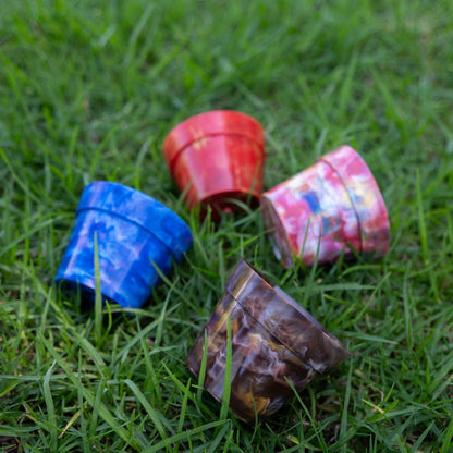 All four BRAD recycled plastic pot plant colours displayed on grass - Blueberry blue, Strawberry red, Chocolate brown and Fruit Salad multicolour, eco-friendly planters by Banish Australia